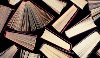 image of a stack of hard back books on the end of the pages toned with a retro vintage warm instagram like filter app or action effect