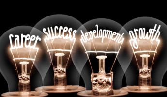 Photo of light bulb with shining fibers in shapes of CAREER , SUCCESS, DEVELOPMENT, GROWTH concept words isolated on black background