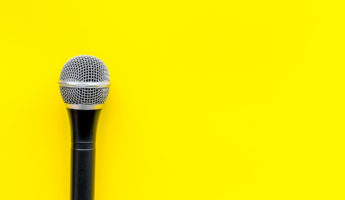 Record studio set. Blogger, journalist or musician work space with microphone on yellow background top view space for text