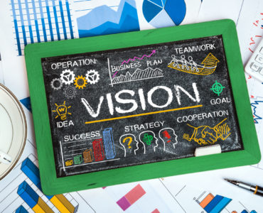 vision concept with business elements on blackboard