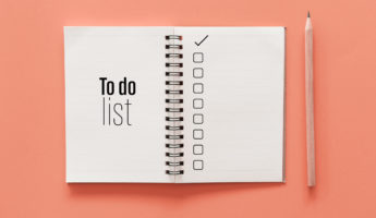 Notebook and pencil with to do list words on pastel color background.