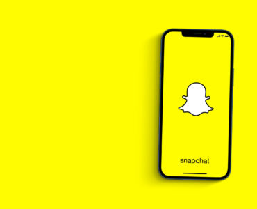 Snapchat app on smartphone screen on yellow background. Social media. Top view. Rio de Janeiro, RJ, Brazil. July 2021.
