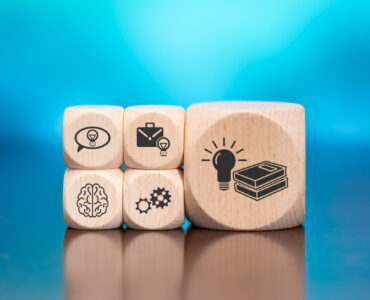 Wooden blocks with symbol of knowledge concept on blue background