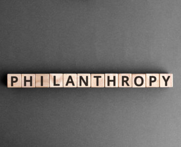 Philanthropy - word from wooden blocks with letters, to help poor people altruism charity philanthropy concept,  top view on grey background